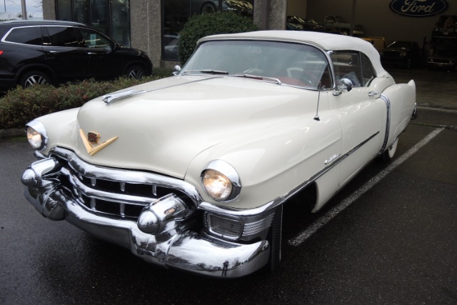 Till kund i Västerås tog vi hem en vit 1953 Cadillac Eldorado som syns på bilden. Parkerad framför garage på asfalt