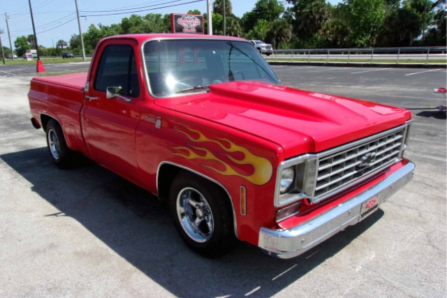 Image of red 1975 Chevrolet C10 purchased with safe deals in Florida. The car is parked on asphalt on a sunny day